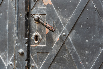 Old Door Handle. Close-up of an old door handle and lock, ideal for backgrounds, vintage themes, detail themes.

