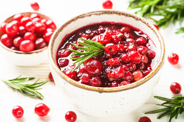 Cranberry sauce in a bowl on white table.