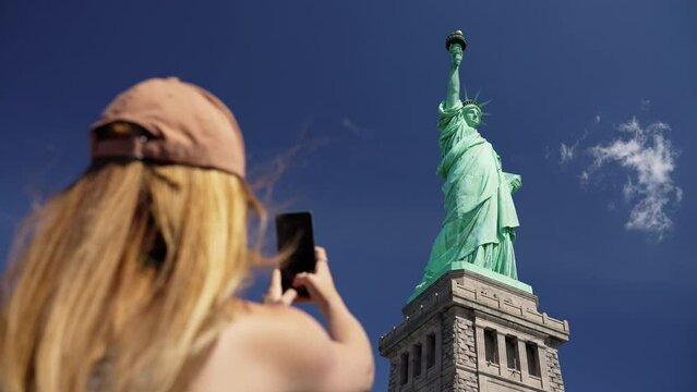 Low Angle Shot Of A Woman Taking A Picture Of The Statue Of Liberty
