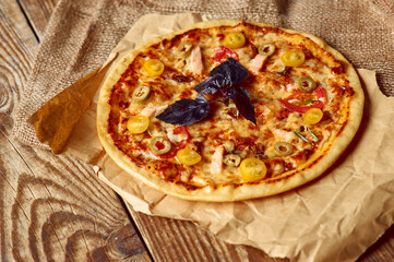 Delicious pizza served in country style on wooden table with free space for text.