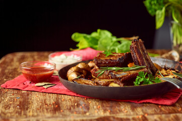 Roasted pork ribs with grilled vegetables in a pan. Meat grilled close up. Copy space