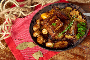 Roasted pork ribs with grilled vegetables in a pan. Meat grilled close up. Copy space
