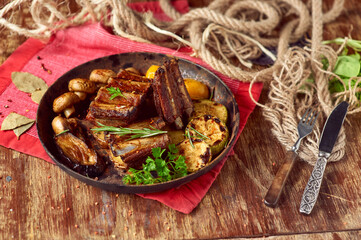 Roasted pork ribs with grilled vegetables in a pan. Meat grilled close up with country food design. Copy space