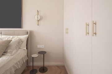 Modern minimalist aesthetic bedroom interior design in warm shades. Electrical outlet, bedside tables, LED light over the bed.