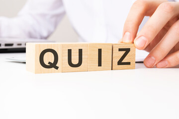 hand holding wooden cube with Quiz text on table background. financial, marketing and business concepts