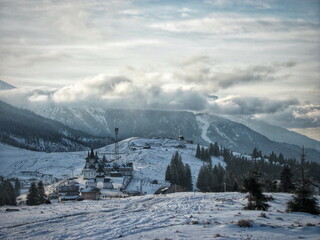 Fototapeta na wymiar Ski resort in the mountains in winter in the evening