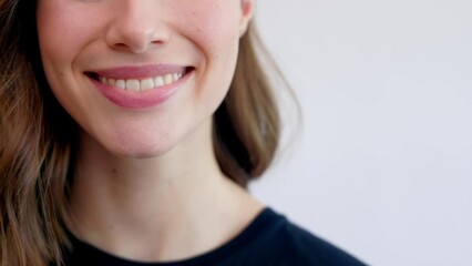 Close-up video of naturally smiling woman isolated on white background, place for copy space.. Big smile and white teeth. Female beauty close-up - Powered by Adobe
