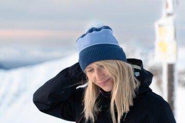 Fototapeta na wymiar Beautiful blond woman in a blue cap on the Zawrat pass in the winter Tatra Mountains. Winter and sunrise in Polish mountains