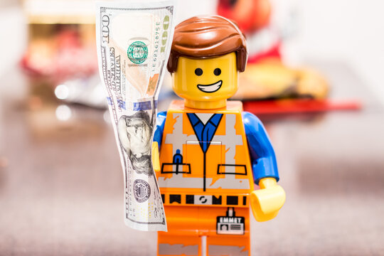 Slovakia. Sala. 01/01/2023. Banknote in the hands of a LEGO worker, with a joyful expression on his face.. Money in the hands of Lego Movie 2 Emmet Smile.