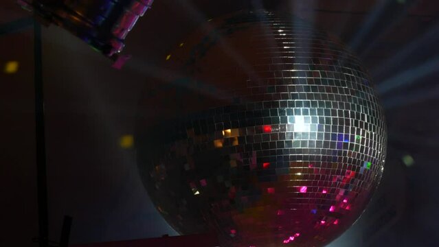 Silver mirror disco ball at a party or celebration. Lighting design on the stage of the birthday party in the club. Abstract background of retro disco ball