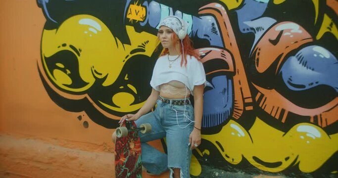 Gen z skater woman listening to music on urban street