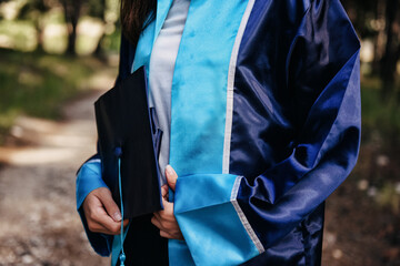 Girl Wearing Graduation Gown and Holding Graduate Cap
