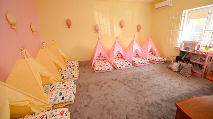 Baby cots in the kindergarten for naps in the form of tents.