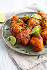 Homemade Grilled Jerk Chicken with Lime on a Plate, side view.