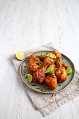 Homemade Grilled Jerk Chicken with Lime on a Plate, side view. Space for text.