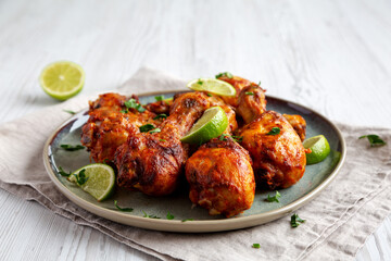 Homemade Grilled Jerk Chicken with Lime on a Plate, low angle view.