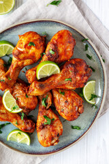 Homemade Grilled Jerk Chicken with Lime on a Plate, top view. Flat lay, overhead, from above.