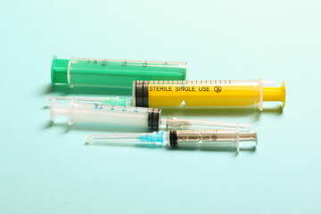 Top view of medical syringes with needles at blue background with copy space. Injection treatment...
