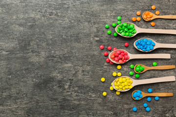 delicious colorful sweet candies on spoon on colored background . Confectionery decor top view with copy space