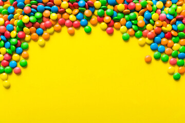 Mixed collection of colorful candy, on colored background. Flat lay, top view. frame of colorful chocolate coated candy