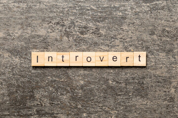 Introvert word written on wood block. Introvert text on table, concept