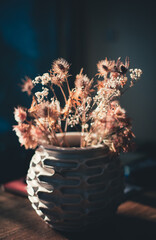 backlited flowers in vase on the table in sunset time