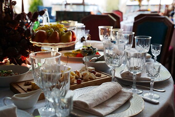 table setting for a festive dinner. empty wine glasses, tableware and snacks.