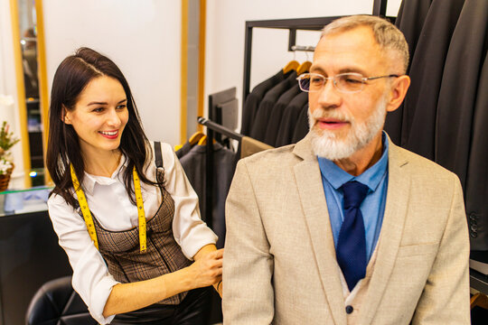 A Professional Tailor Woman Trying On A Tailor-made Suit For An Elderly Man