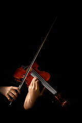 Teen playing violin in black background © Kenishirotie