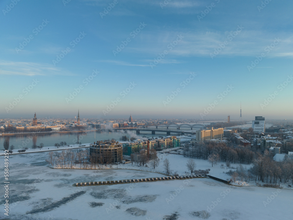 Poster a snowy landscape with a river and bridge in the distance and a city in the distance in the distance
