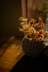 backlited flowers in vase on the table in sunset time