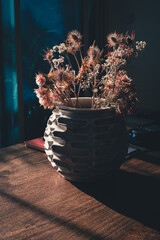 backlited flowers in vase on the table in sunset time