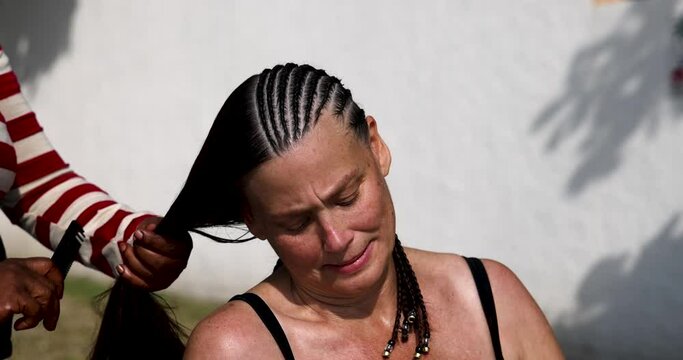 St Maarten island Caribbean beautiful lady hair style. Beautiful woman her long dark hair braided by Caribbean stylist beautician. Fun African style corn rows with beads and jewelry. Tropical beach.