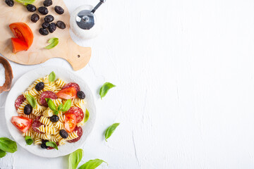 Antipasto salad with pasta, tomato, olives, red onion, bell pepper, salami