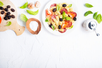 Antipasto salad with pasta, tomato, olives, red onion, bell pepper, salami