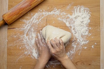 Top down view of pulling up dough to knead it.