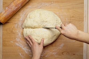Overhead view of cutting dough in half.