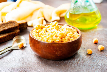 Hummus in a bowl and bread on grey background. Mediterranean snack, vegetarian healthy food concept. Top view, flat lay, copy space.