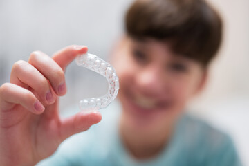 Teenager boy wear simulator orthodontic silicone invisible leveling braces for teeth.  Dental...