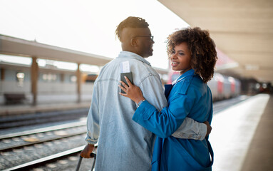 Happy Travellers. Portrait Of Young Black Couple Hugging At Railway Station