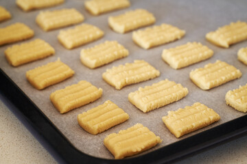 Raw Christmas cookies on a baking sheet, before baking