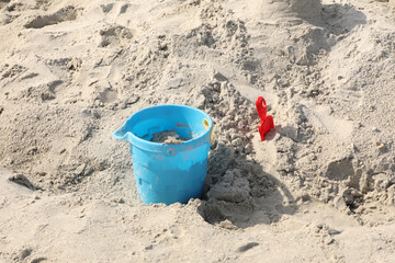 blue bucket and shovel in the sand at the beach