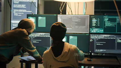 Diverse criminals hacking security server with malware, working on cyberbullying late at night. Hackers phishing for information, stealing valuable data, breaking firewall encryption.