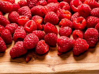 Fresh raw raspberry on wooden board and white isolated background. Fruit product for sale.