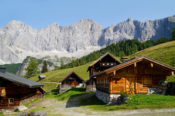 Obraz premium hiking trail leading through the scenic alpine village Neustatt Alm or Neustatt valley by the foot of Dachstein mountain in the Austrian Alps in Steiermark or Styria region (Austria)