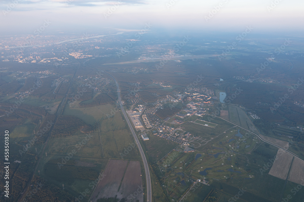 Poster an aerial view of a city and a highway from a plane window with a view of the countryside and a rive