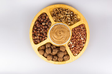 Peanuts, walnuts and hazelnuts in a wooden box with compartments. Three different types of nuts, shelled and shelled, decorative assortment and ready to eat. Closeup, isolated, from above.