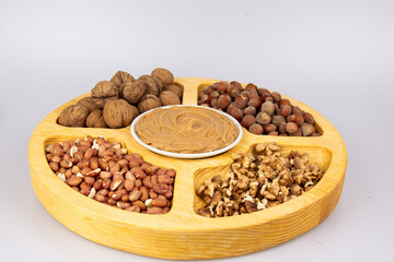 Peanuts, walnuts and hazelnuts in a wooden box with compartments. Three different types of nuts, shelled and shelled, decorative assortment and ready to eat. Closeup, isolated, from above.