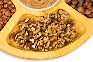 Peanuts, walnuts and hazelnuts in a wooden box with compartments. Three different types of nuts, shelled and shelled, decorative assortment and ready to eat. Closeup, isolated, from above.