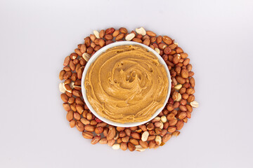Creamy peanut butter, peanut butter in an open glass jar in the center of a peanut food background....